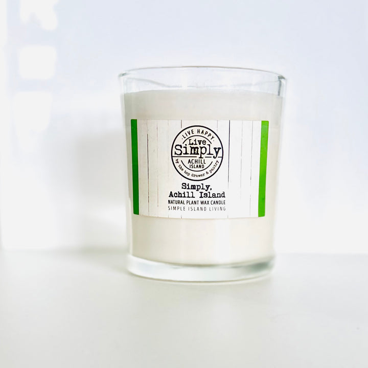 Simply Achill Island natural plant wax candle in a clear glass jar with a green-bordered label.
